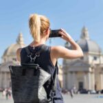 turista di spalle scatta una foto a Roma