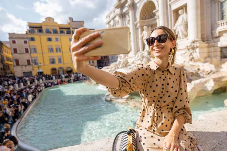 turista si scatta un selfie con la fontana di trevi sullo sfondo
